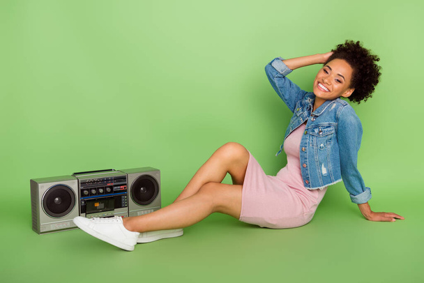 Full size photo of nice millennial lady sit with boom box wear dress shirt sneakers isolated on green background - Photo, Image