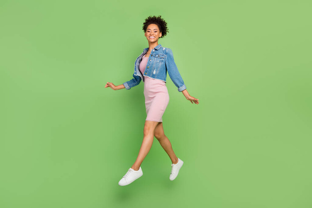 Full length photo of cute young lady run wear dress shirt sneakers isolated on green background - Foto, imagen