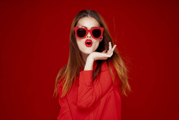 attractive woman in red shirt sunglasses fashion red background - 写真・画像