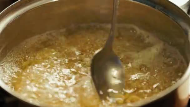witte blanke hand roeren pasta met kruiden koken in water met een lepel - Video