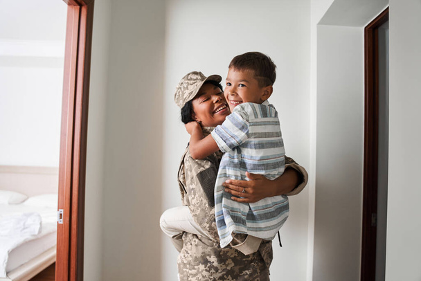 Black female soldier holds son on arms after army - Fotoğraf, Görsel