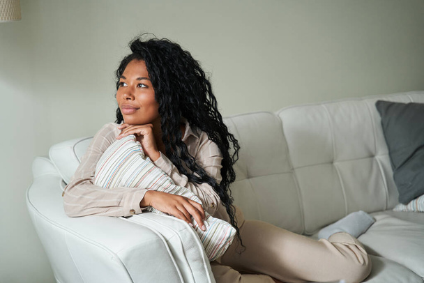 Young black woman sitting on couch and thinking - Φωτογραφία, εικόνα