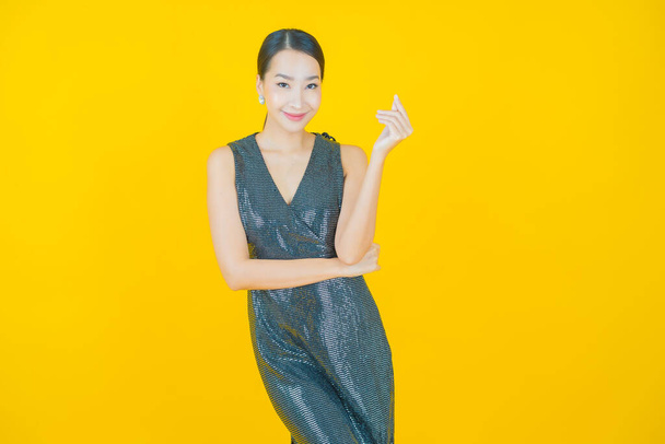 Retrato hermosa joven asiática mujer sonrisa con acción en color fondo - Foto, Imagen