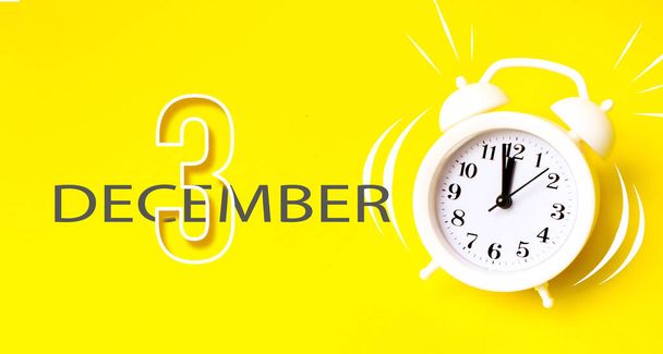 3 Δεκεμβρίου. Ημέρα 3η του μήνα, ημερομηνία ημερολογίου. Λευκό ξυπνητήρι με ημερολογιακή ημέρα σε κίτρινο φόντο. Μινιμαλιστική αντίληψη του χρόνου, διορία, ώρα για δουλειά, πρωί. Χειμερινός μήνας, ημέρα του έτους έννοια - Φωτογραφία, εικόνα