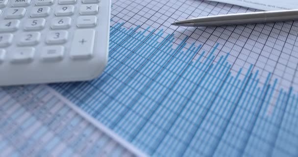 Calculadora gráficos de negocios estadísticas financieras y pluma en la tabla - Metraje, vídeo