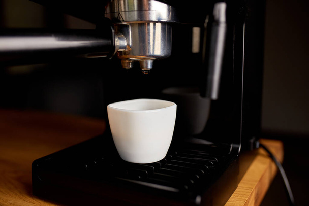 Koffiezetapparaat klaar voor het bereiden van een koffie. Kopje koffie wordt bereid met behulp van een Espresso Machine In een Cafe. - Foto, afbeelding