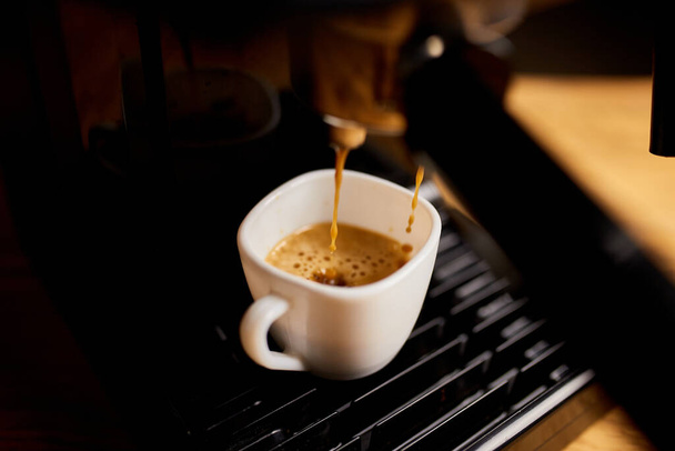 Yksityiskohta ammatillinen kahvinkeitin tippuu kahvia tyhjään kuppiin kahvilassa, kone tekee täydellisen kahvin herkullista hajua,. Espresso kahvinkeitin Espresso kahvi - Valokuva, kuva