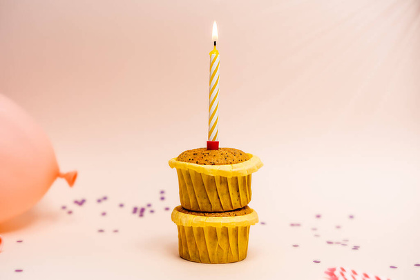 verjaardag concept, cupcake op roze achtergrond met kaars - Foto, afbeelding