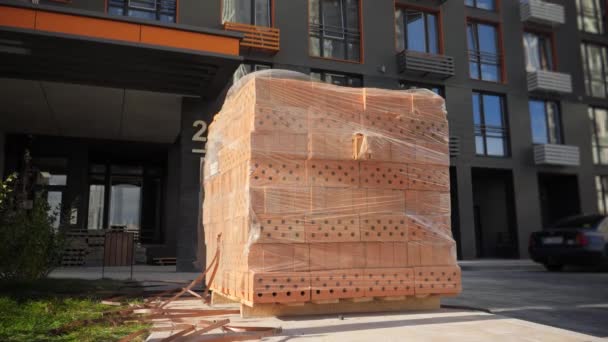 Συσκευασμένη παλέτα από πορτοκαλί τούβλα σε σημείο buidling - Πλάνα, βίντεο