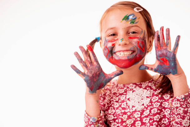 Children's make up. Portrait of happy smiling beautiful young girl with colorful painted face against white background. Copy space. - Photo, Image