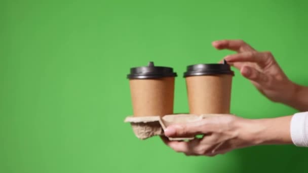 Χέρια κρατώντας δύο φλιτζάνια καφέ χαρτί με μαύρο καπάκι - Πλάνα, βίντεο