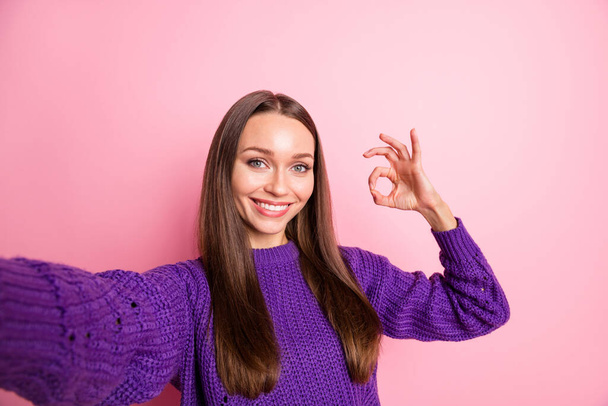 Photo of cute adviser lady shoot selfie fingers show okey wear violet sweater isolated pink color background - Fotó, kép