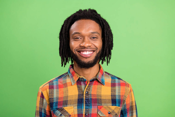 Photo of cheerful positive african guy toothy beaming smile wear plaid shirt isolated green color background - Фото, изображение