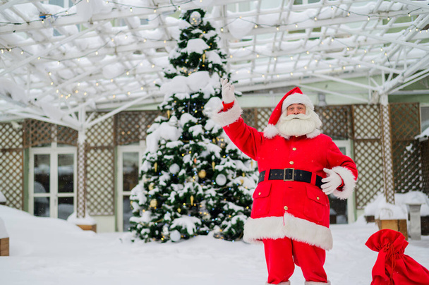 Santa claus wishes a merry christmas outdoors - Photo, Image