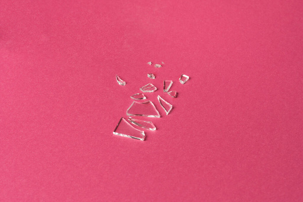 Broken glass on pink background, deconstruction trend - Foto, imagen