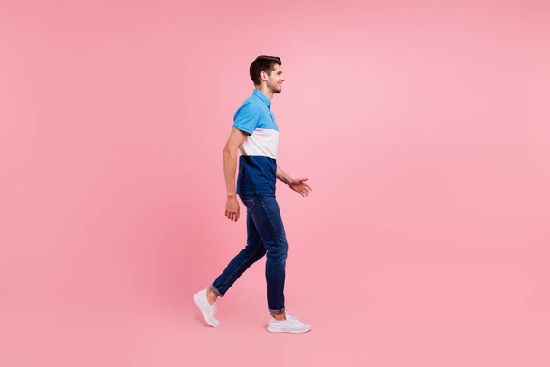 Full size profile photo of funny brunet millennial guy go wear polo jeans sneakers isolated on pink background - Fotografie, Obrázek