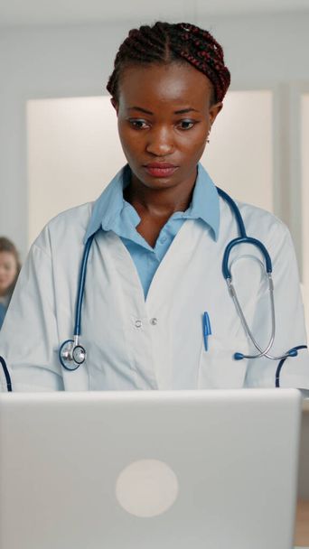 Medico donna con stetoscopio che lavora con laptop moderno - Foto, immagini