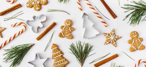 Christmas Banner. winter, new year composition. Christmas frame made of cinnamon sticks, candies, gingerbread on white background. Flat lay, top view, copy space. - Photo, image