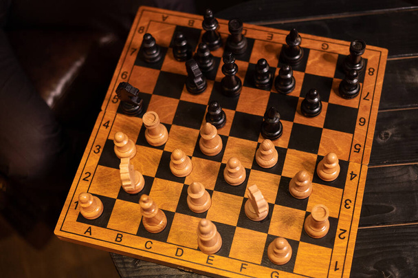 Ručně dělané šachy. Dřevěná šachovnice s černobílými vyřezávanými figurami - Fotografie, Obrázek