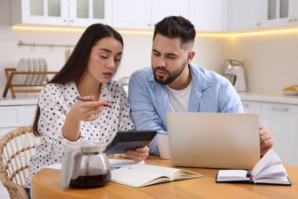 Young couple discussing family budget in kitchen - Foto, Bild