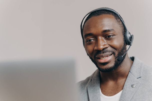 Fiatal elégedett afro-amerikai férfi callcenter ügynök beszél ügyfél, tanácsadás ügyfél online - Fotó, kép