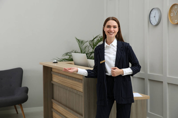 Portrait of beautiful receptionist near counter in hotel - Foto, afbeelding