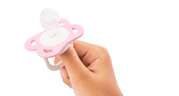 Female Hand Holding Pink Pacifier - Foto, Imagen