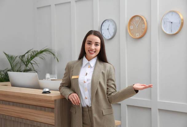 Portrait of beautiful receptionist near counter in hotel - 写真・画像