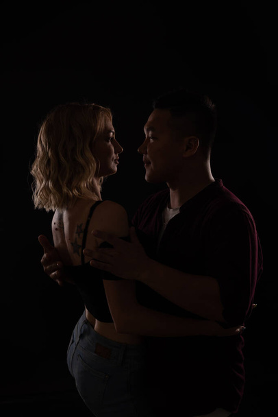 un uomo e una donna danzano alla musica nel buio di una discoteca - Foto, immagini