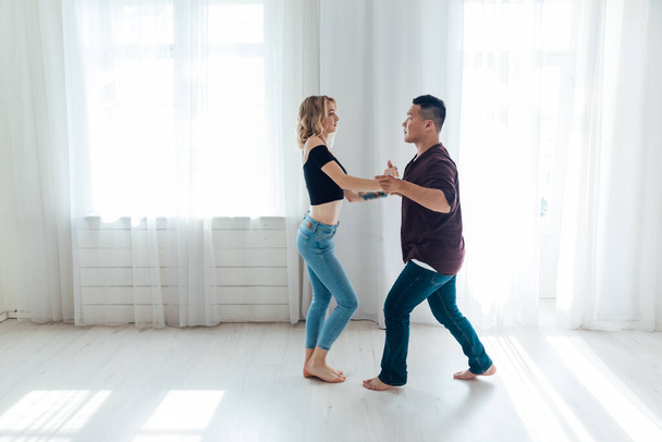 a man and a woman dance to the music of a pair dance of bachata - Photo, Image