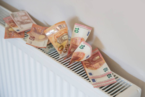 Home heating expenses and savings concept. Money on heating radiator. - Photo, Image