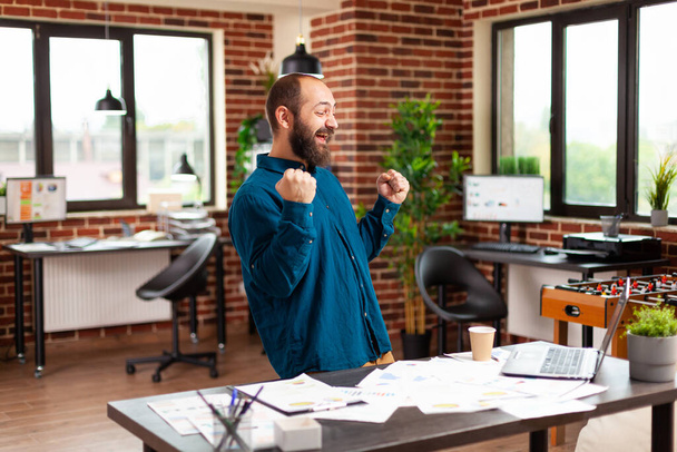 Homem de negócios rindo dançando no escritório de startup celebrando o projeto de marketing bem sucedido - Foto, Imagem