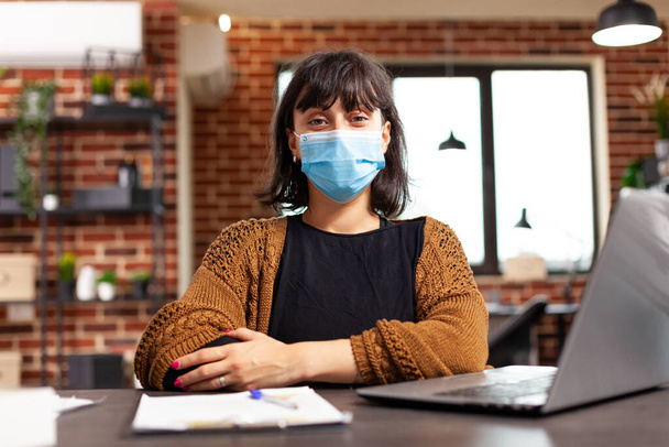 Портрет деловой женщины в медицинской маске для предотвращения заражения коронавирусом - Фото, изображение