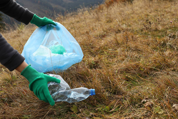 Woman with trash bag collecting garbage in nature, closeup. Space for text - Fotoğraf, Görsel