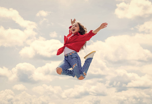 smiling child jumping so high. carefree and joyful. kid fashion style. teenage girl on sky background outdoor. hipster kid jump. happy childrens day. happy childhood. Confident and stylish beauty - Foto, Imagen