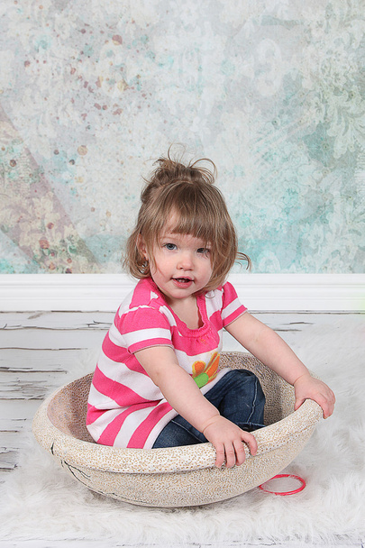Beautiful Little Girl sitting in basket - Foto, afbeelding