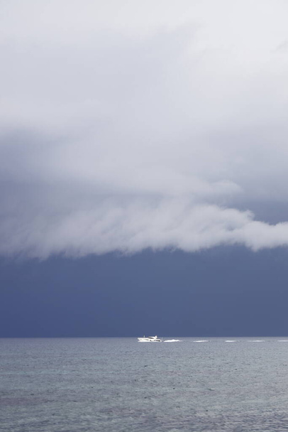 Bateau naviguant dans la tempête à venir. Voilier par mauvais temps naviguer en pleine mer. Voilier sous un ciel nuageux lourd. - Photo, image