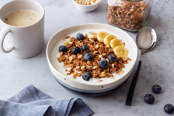Granola with yogurt, blueberries, nuts, banana and honey. Muesli. Healthy eating. Vegetarian food - Фото, изображение