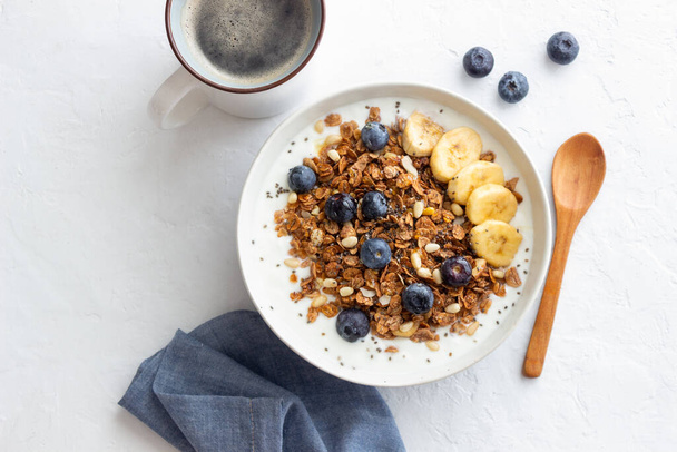 Granola with yogurt, blueberries, nuts, banana and honey. Muesli. Healthy eating. Vegetarian food - Fotó, kép