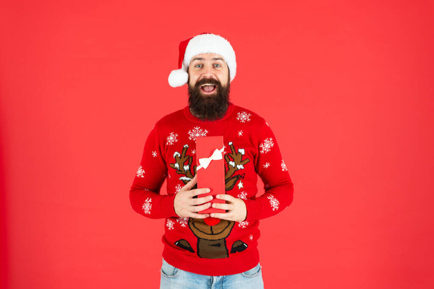 happy bearded man in santa hat open gift box on red background, new year - Photo, Image