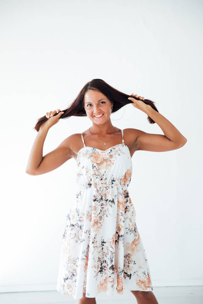 брюнетка в летнем платье в белой комнате - Фото, изображение