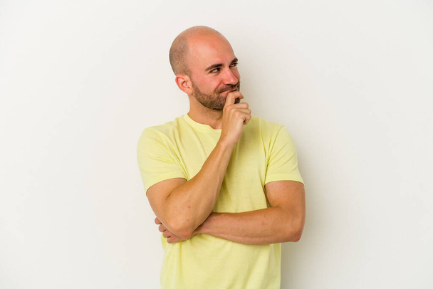Young bald man isolated on white background relaxed thinking about something looking at a copy space. - Photo, Image