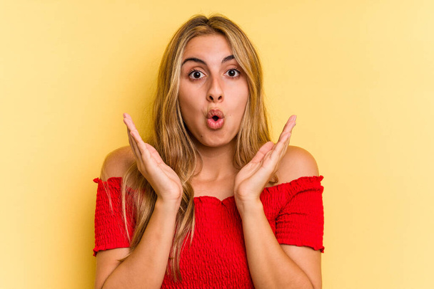 Young caucasian blonde woman isolated on yellow background  surprised and shocked. - Photo, Image