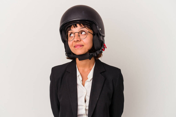 Joven mujer de negocios de raza mixta que lleva un casco de moto aislado soñando con lograr objetivos y propósitos - Foto, imagen