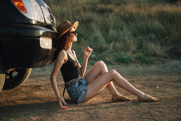 woman in sunglasses near car travel summer vacation landscape - Foto, afbeelding