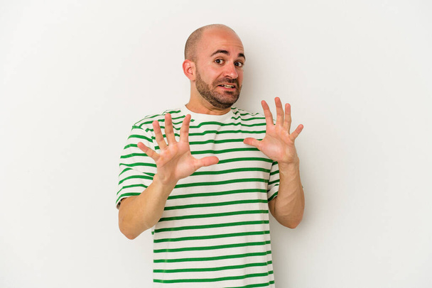 Young bald man isolated on white background being shocked due to an imminent danger - 写真・画像