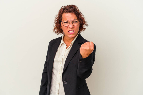 Donna d'affari latina di mezza età isolata su sfondo bianco che mostra pugno alla macchina fotografica, espressione facciale aggressiva. - Foto, immagini