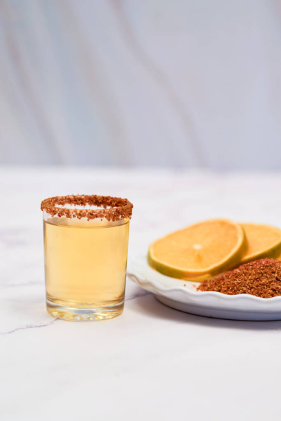 Mezcal shot mexican drink with orange slices and chili pepper - Foto, Bild