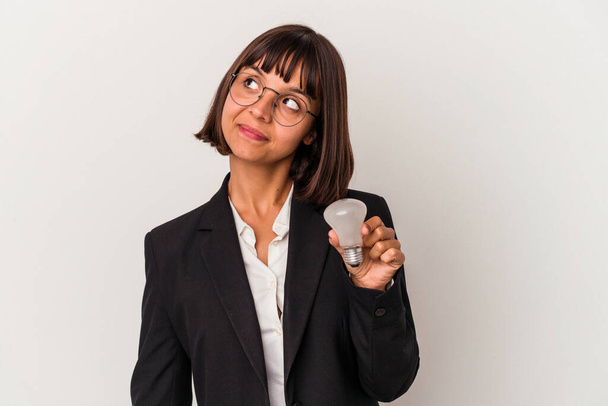 Молода змішана гонка бізнес-леді тримає лампочку ізольовано на білому тлі мріє досягти цілей і цілей
 - Фото, зображення