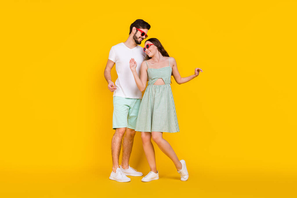 Foto de pareja de viajeros despreocupados disfrutar de fiesta danza abrazo desgaste traje casual aislado color amarillo fondo - Foto, Imagen